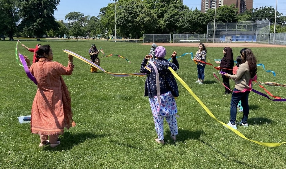 Photo: Bengali HEAL participants engaging in dance ribbon activity to learn about somatic techniques for self and co-regulation in Dentonia Park.